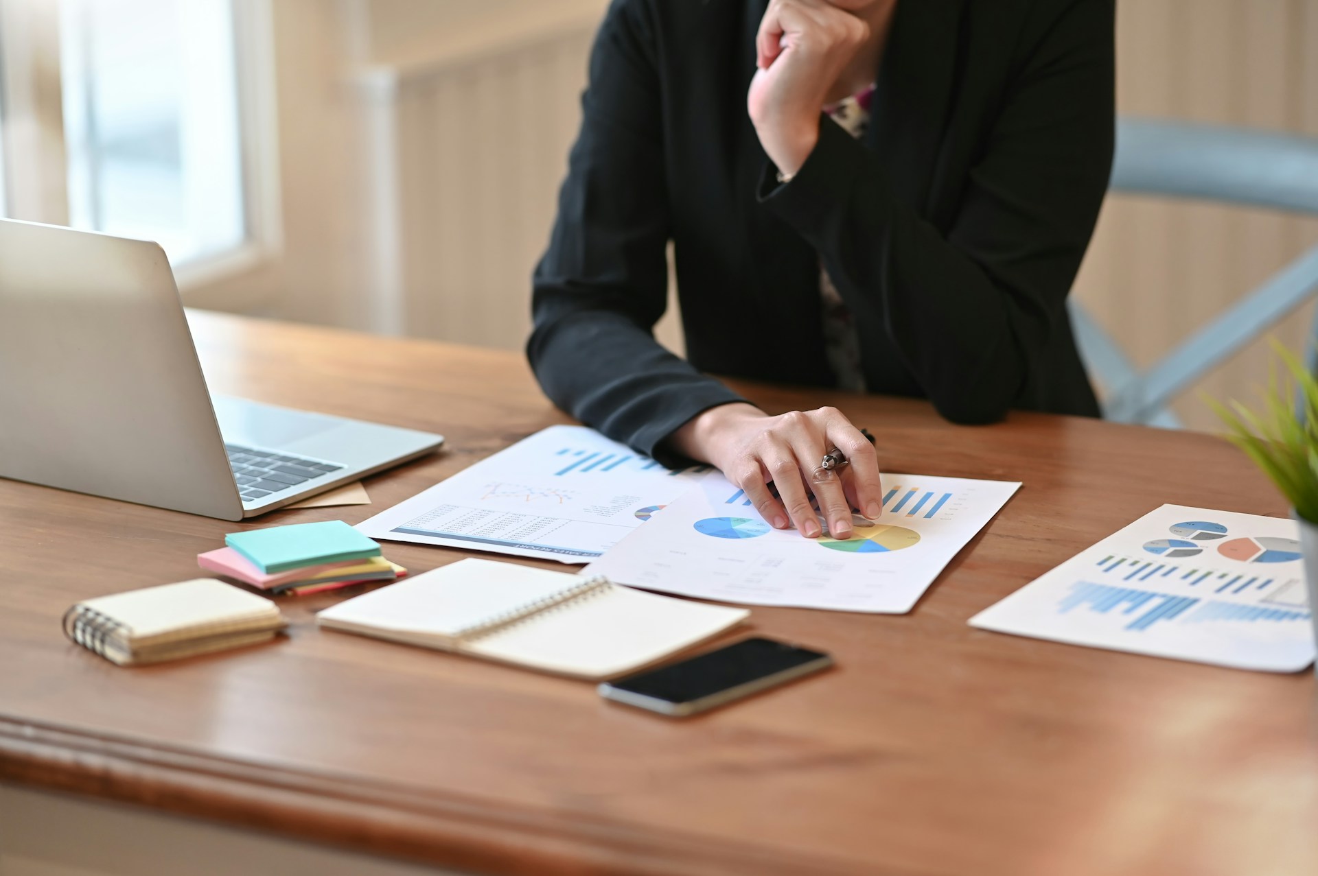 Profesional revisando reportes y gráficos de datos sobre un escritorio de oficina