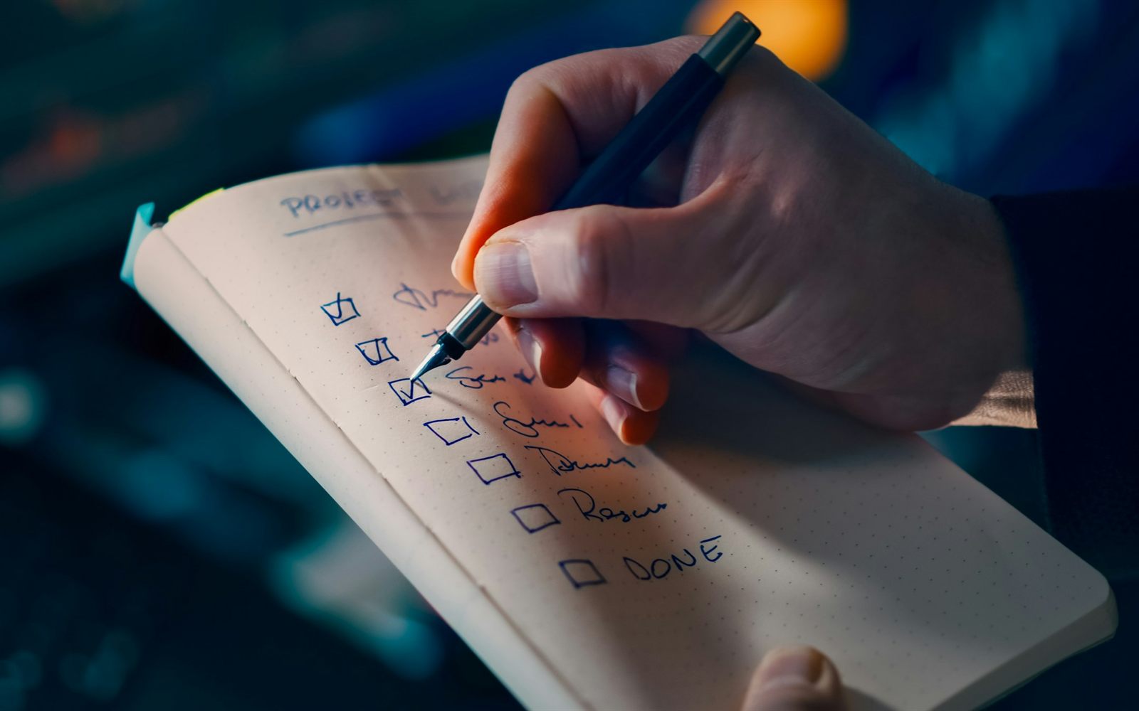 Mano marcando una lista de verificación en una libreta